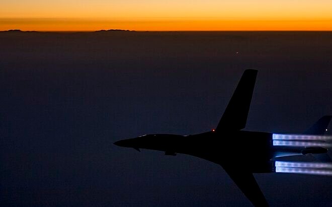 U.S. Navy warships escorting commercial oil tankers safely through the strategic Strait of Hormuz.